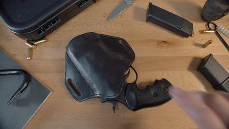 tabletop with tactical gear and revolver in holster