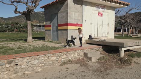 black and white dog playing with young female child outside locked building