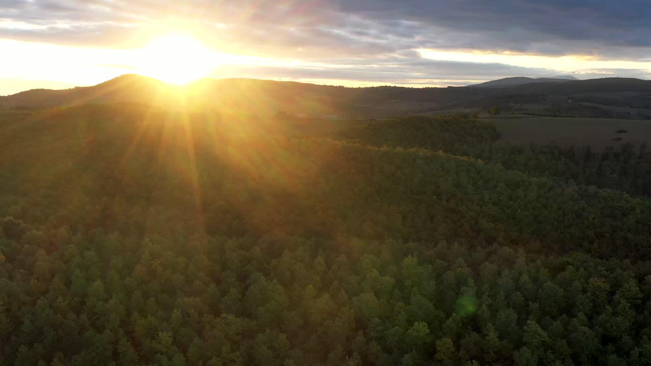 sunrise over wild forest in Italy. nature Aerial view. sunrise rays shining through branches in autumn mountains