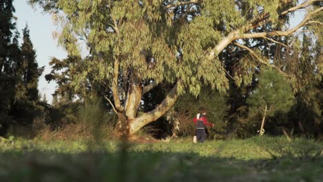 amplia, tiro inclinado hacia abajo de un niño caucásico corriendo en los campos, vista a nivel del suelo 120fps