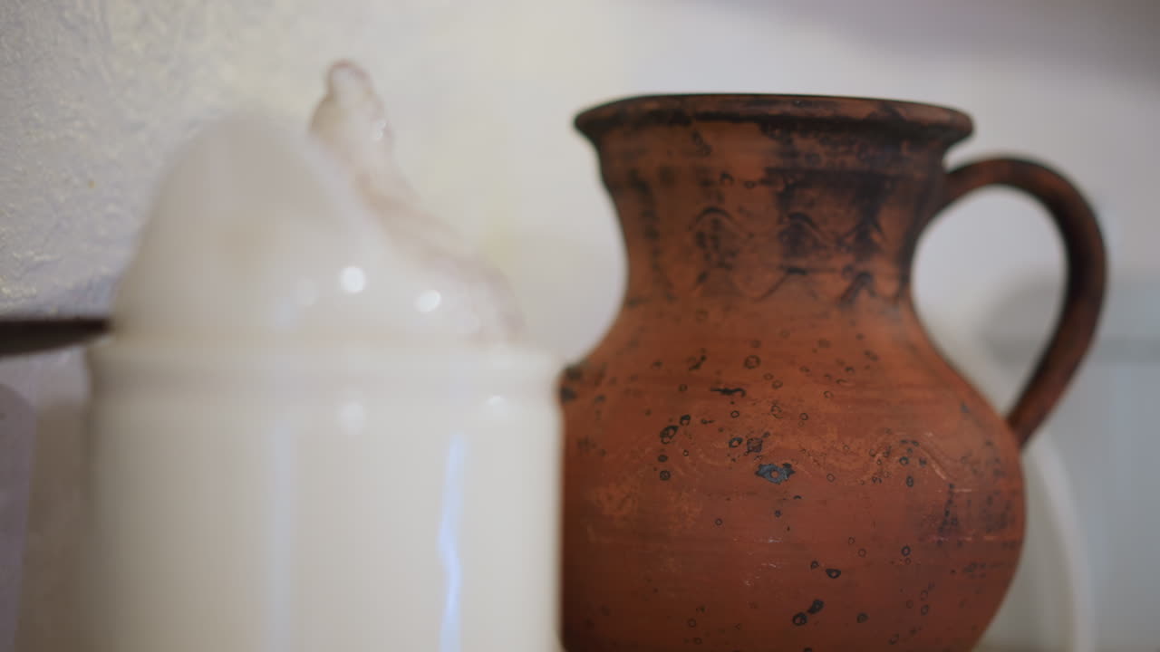 Escena de cocina casera con un tarro de crema, espuma suave desbordando un recipiente de cerámica blanca, telón de fondo de una jarra de terracota envejecida, luz natural cálida, poca profundidad de campo, decoración acogedora de casa de campo, artesanal.