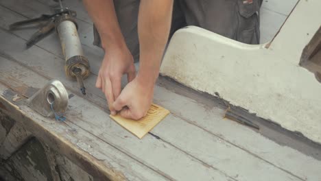 placing wooden capping over hole on wooden boat planking starboard side and sealing with sika flex