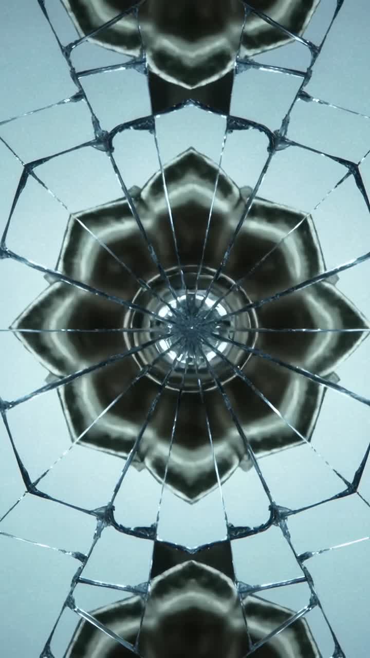 Video verticale: primo piano di mandala rotante in vetro incrinato mentre la luce si sposta, mostrando evidenziazioni in movimento