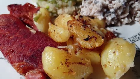 cena de judías verdes, arroz integral, papas al horno y chuletas de cerdo fritas servidas en un plato blanco decorativo
