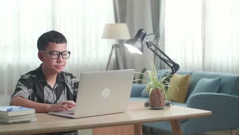 boy studying on a laptop at home