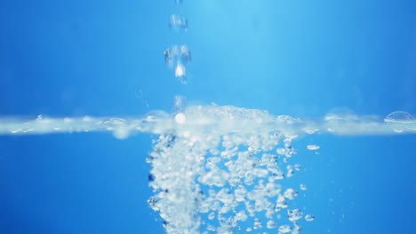 Vista-Macro-De-Dinámica-De-Fluidos-De-Gotas-De-Agua-Dulce-En-Movimiento-Sinfonía-De-La-Naturaleza-Efecto-De-Ondulación-Del-Agua-En-Cámara-Lenta-En-Tono-Azul