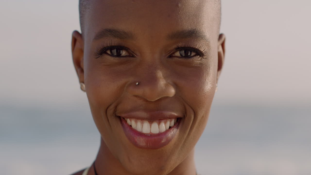 Portrait happy african american woman smiling at beach