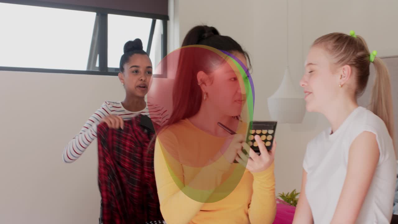 Makeup artist applying eyeshadow with palette after friend showing plaid shirt, sequin dress beauty