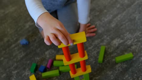 girl playing with building blocks in living room 4k