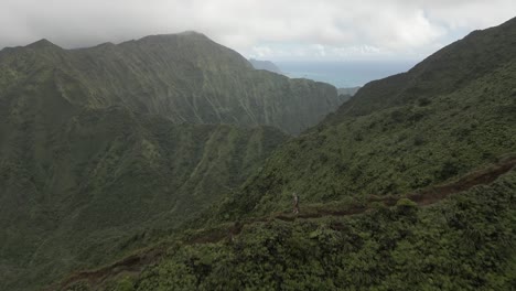 Lone-hiker-on-remote-ridge-trail-in-rugged-mountains-of-Oahu,-Hawaii