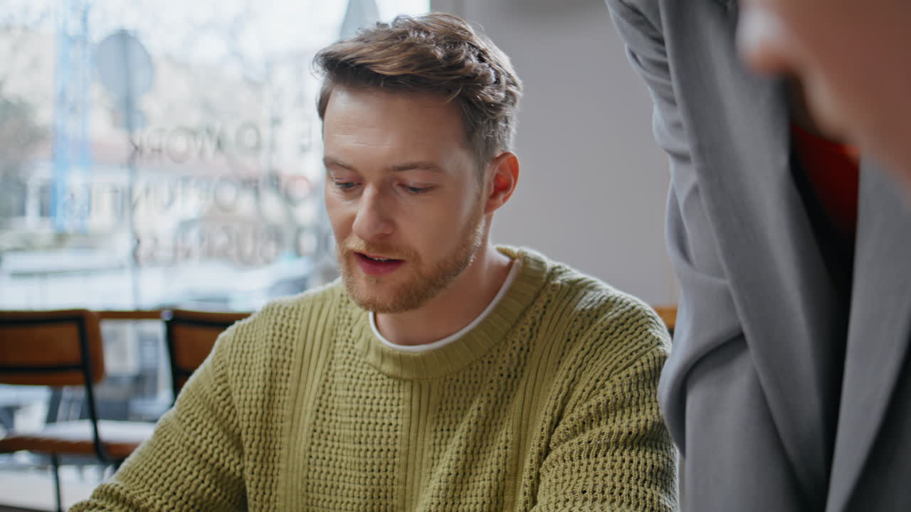 Two coworkers sharing ideas at big windows interior closeup. Designer talking