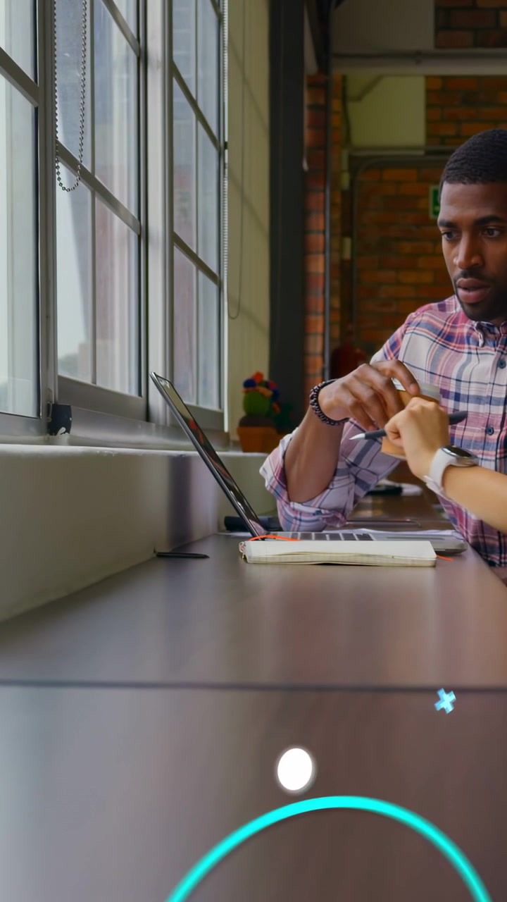 Video verticale: Dopo aver consegnato una tazza, un uomo inclina il laptop mentre un collega digita, con overlay che supportano l'istruzione.