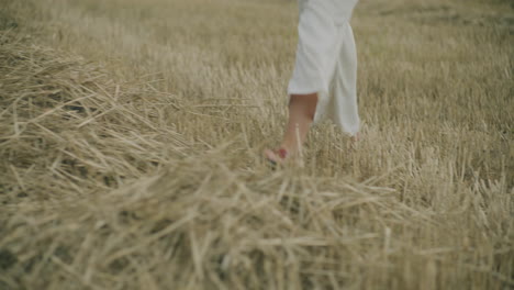 female walking on harvested field