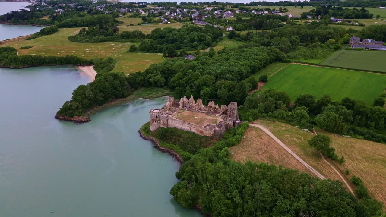 Château du Guildo, castle along coast, France. Aerial drone tilt-down forward