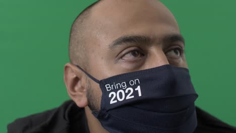 hombre adulto con máscara de algodón tráelo en 2021 mirando fuera de cámara