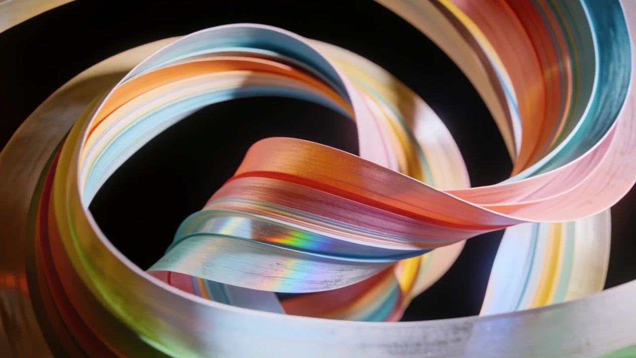 Rotating camera showing ribbon twisting into loops on black backdrop under studio light for sheen