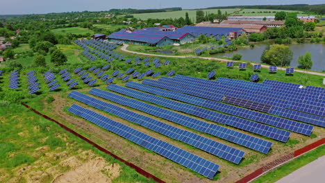 solar power plant among nature. photovoltaic panels in the field and roofs of industrial buildings. renewable clean energy from the sun. aerial view.