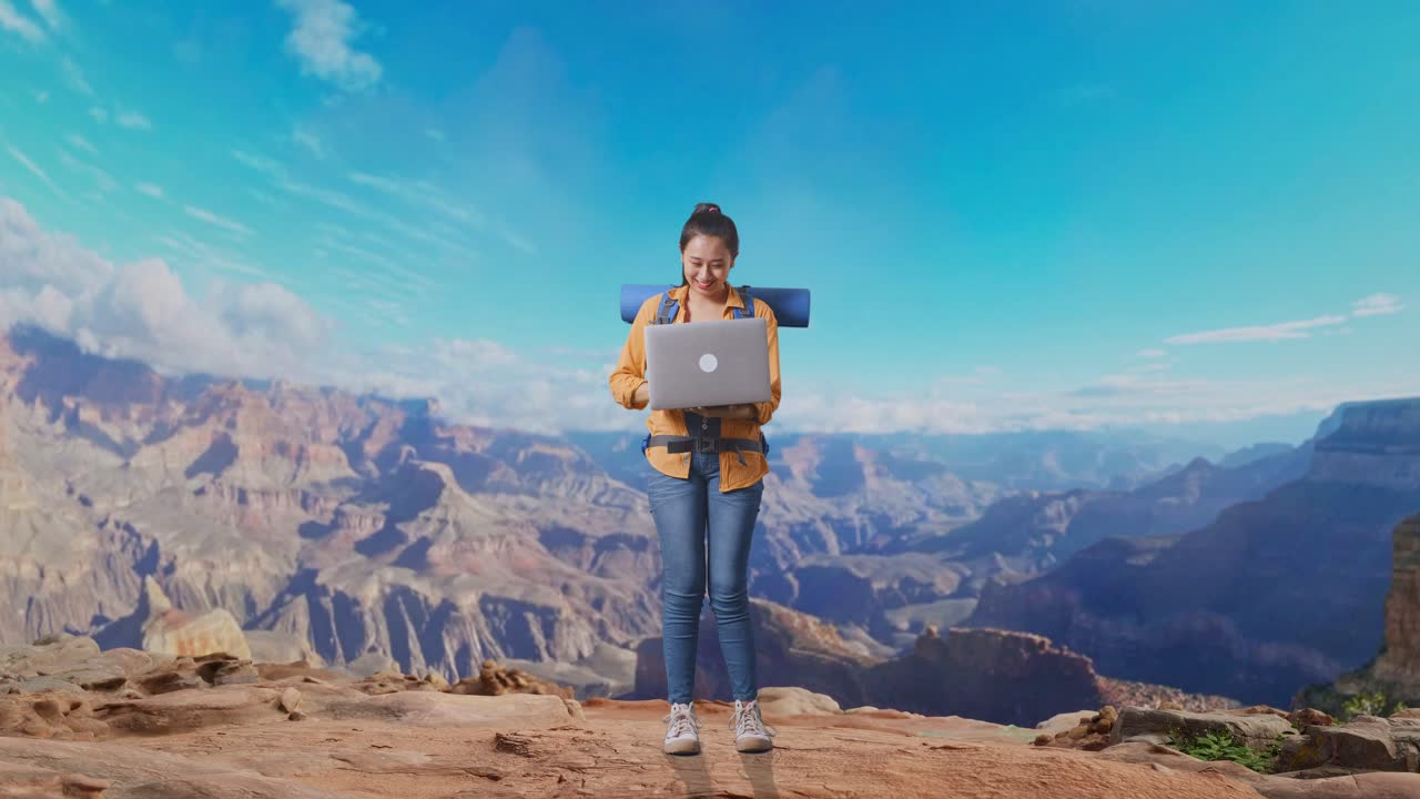Full Body Of Asian Female Hiker With Mountaineering Backpack Looking At A Laptop And Screaming Goal Celebrating The Success While Traveling At The Top Of Mountain