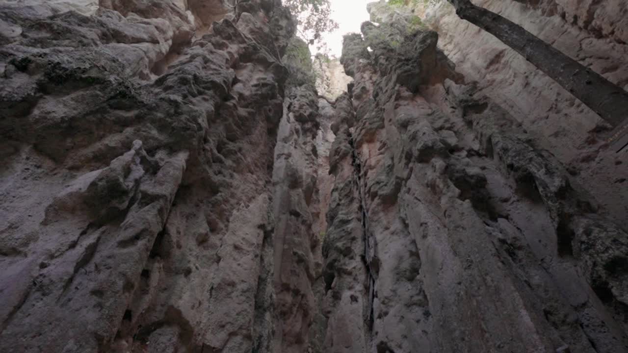 Low angle camera movement looking up through a narrow canyon in los estoraques, colombia