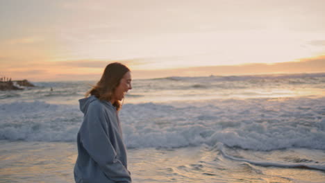 happy girl walking sunset sea water. carefree young woman running ocean waves