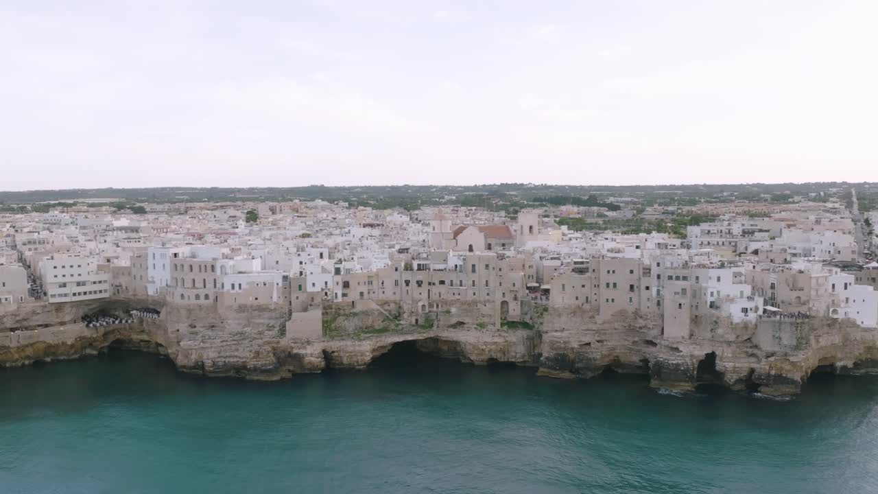 Rekaman udara statis kota yang terletak di atas tebing di atas laut di Polignano a Mare, Italia.