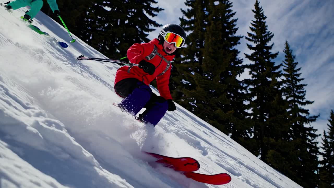 Dynamic low-angle shot of a skier in vibrant gear racing downhill, capturing the thrill of winter