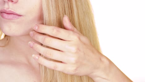 Close-up-of-the-straight-blond-hair-of-a-young-woman-while-brushing-their-natural-brush