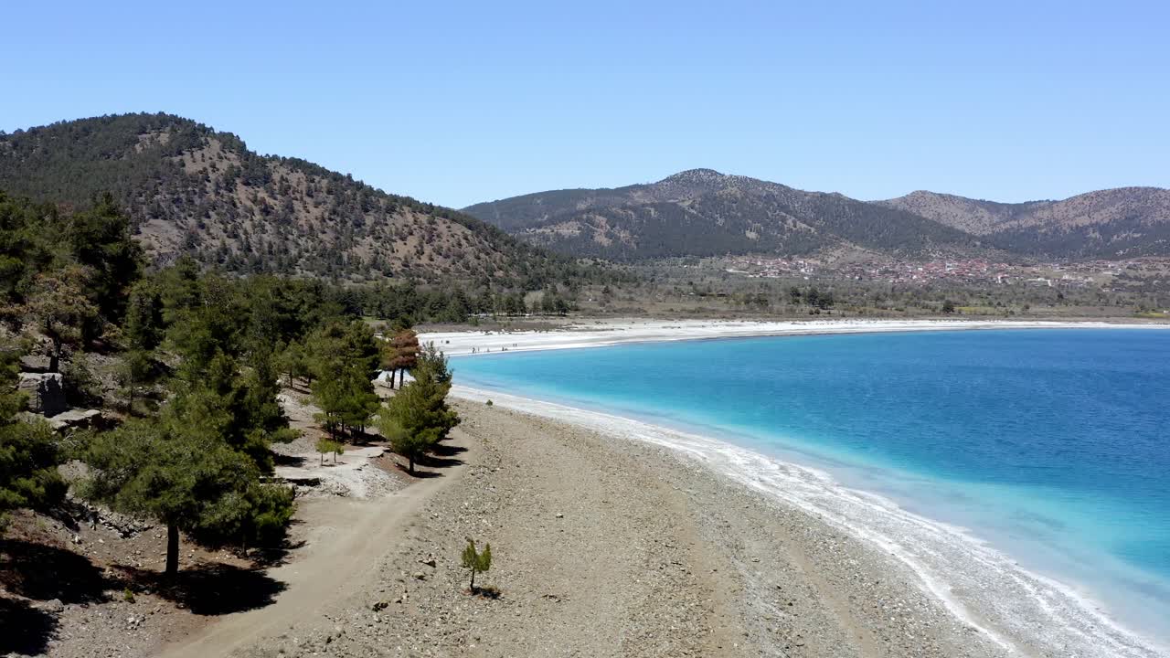 Aerial push shot to Turkish hills around turquoise Lake Salda National park