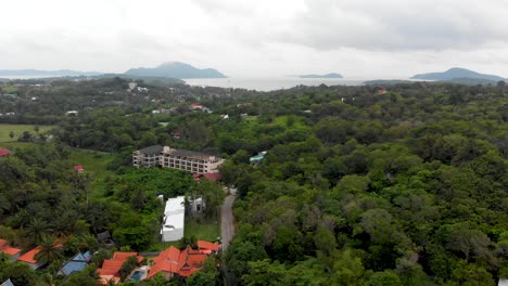 Zipline-aerial-drone-shot-showing-the-expanse-of-Ya-Nui,-with-its-beaches,-green-spaces,-hotels,-residential-areas,-and-Koh-Man-island-across-the-Andaman-Sea,-in-Phuket,-Thailand