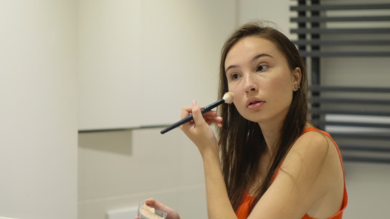 mujer maquillándose en el baño