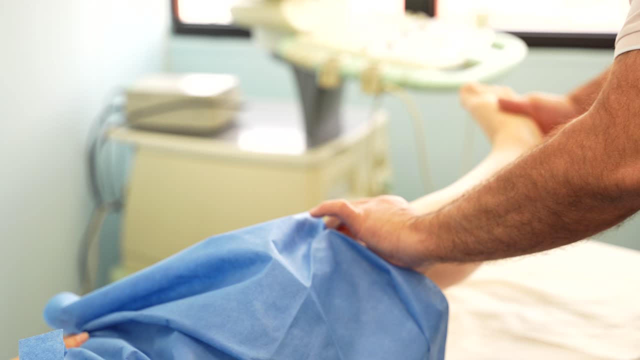 fisioterapeuta masculino doblando la rodilla del paciente en la clínica