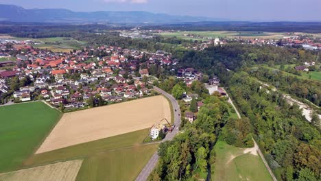 Drone-flight-with-a-DJI-drone-over-the-beautiful-and-rural-village-of-Bätterkinden-with-its-new-and-old-houses-near-Bern-with-the-river-Emme-in-Switzerland