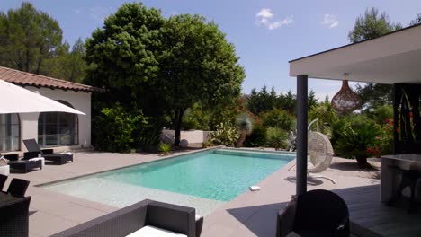 Slow-aerial-shot-of-villas-back-garden-showing-furniture-and-a-swimming-pool