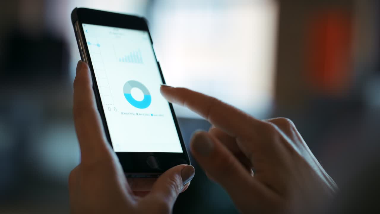 imágenes de video de 4k de una mujer usando un teléfono inteligente para ver un informe financiero