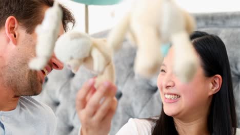 pregnant couple playing with soft toys in bedroom 4k