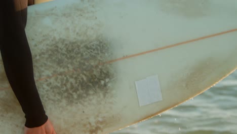 Seitenansicht-Eines-Kaukasischen-Surfers-Mittleren-Alters-Mit-Schützenden-Augen,-Der-Auf-Das-Meer-Am-Strand-Blickt,-4k