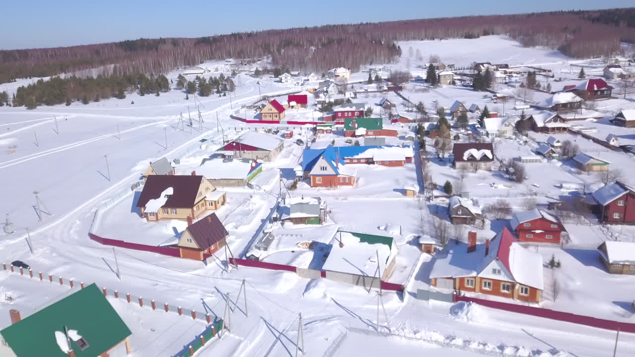 Ilmakuva lumisesta kylästä talvella