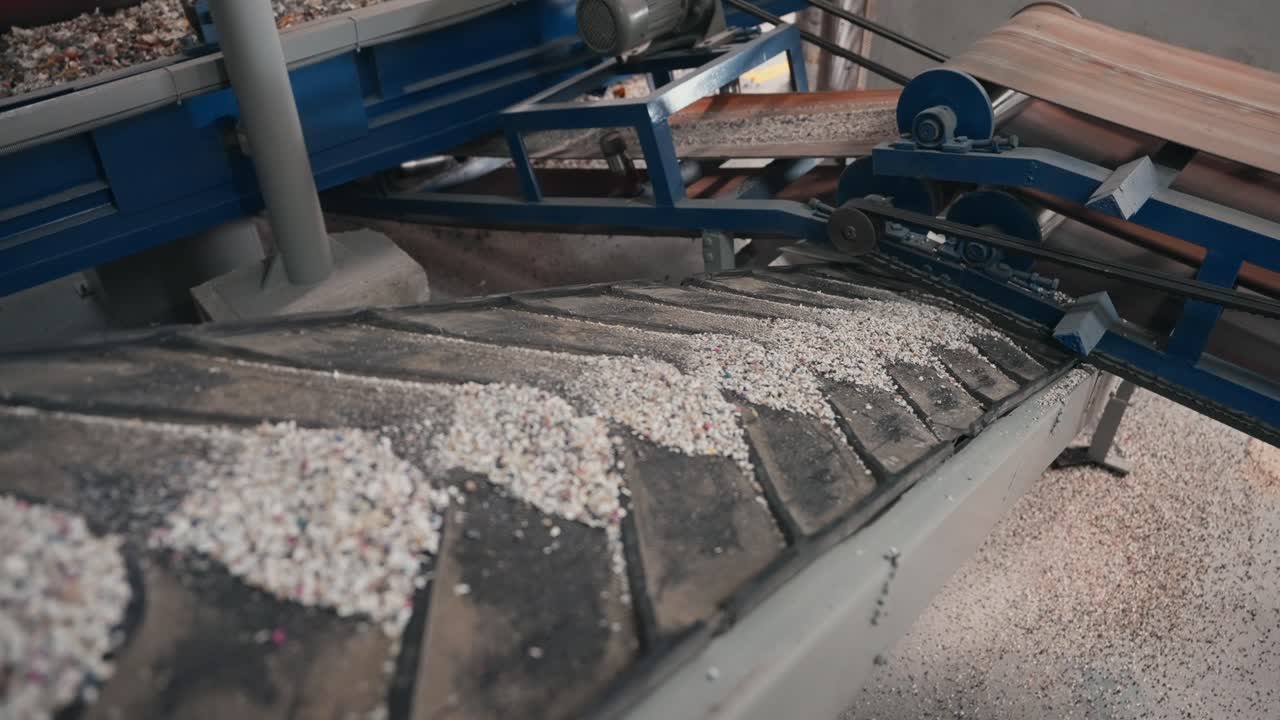 공장 컨베이어 벨트에서 이동하는 재활용 고무 알갱이