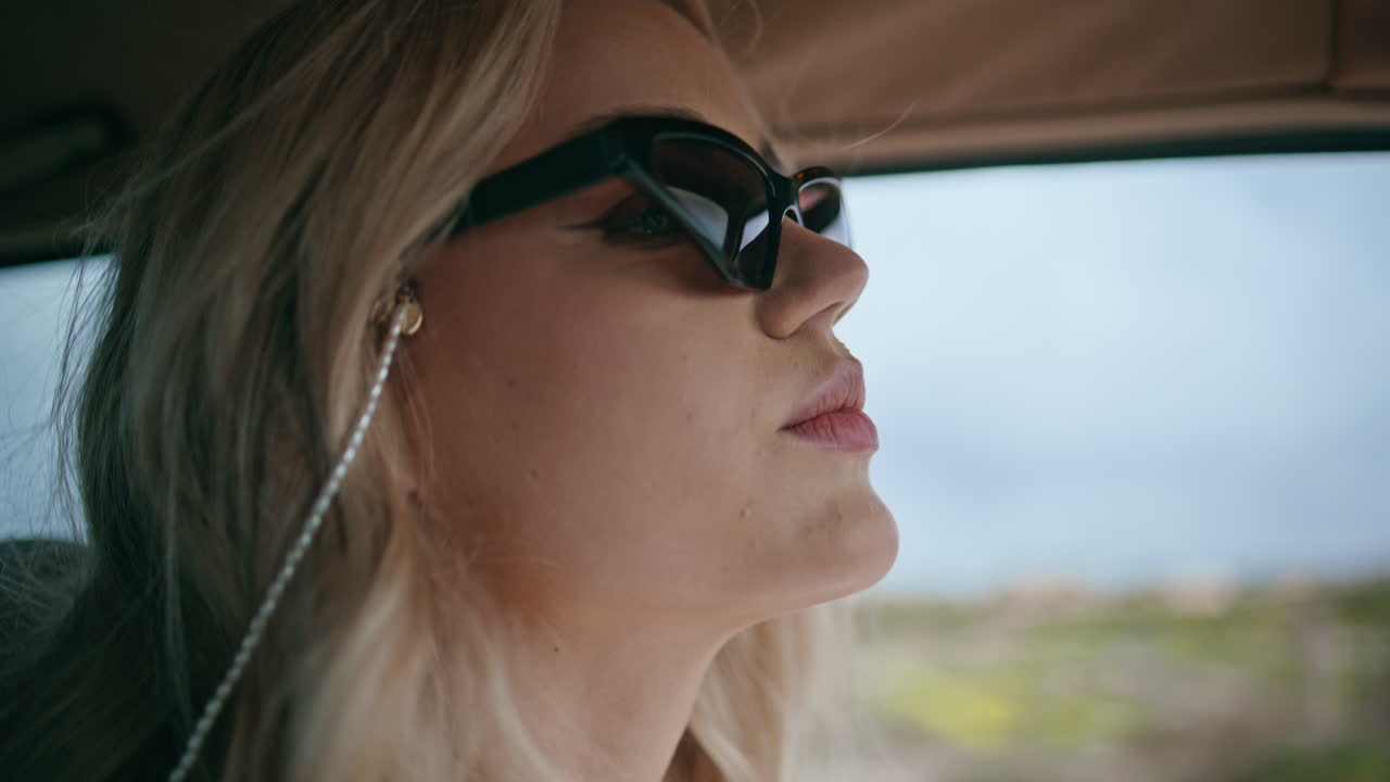 прекрасный путешественник едет на автомобиле в солнцезащитных очках вблизи. девушка едет по шоссе