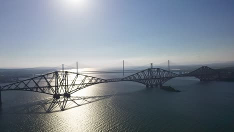 the forth bridges silhouette in south queensferry edinburgh scotland united kingdom aerial video sunset