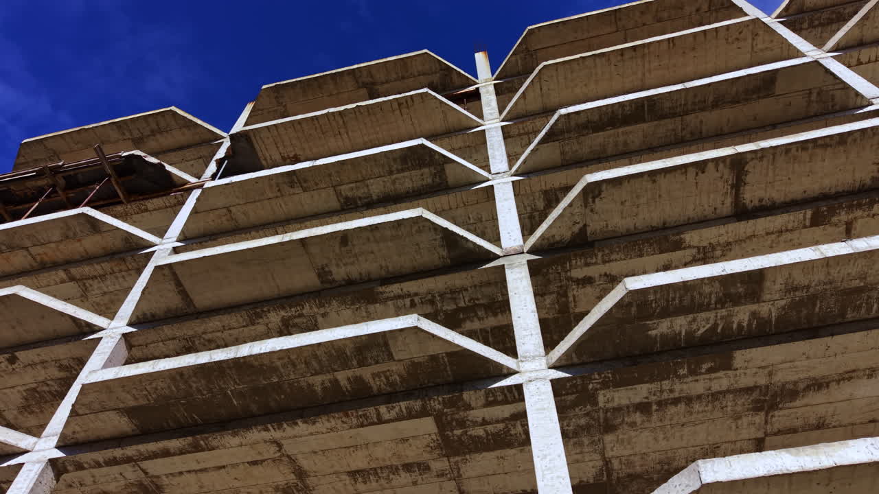 Construction site reveals intricate patterns in concrete against a vivid blue sky during bright afternoon