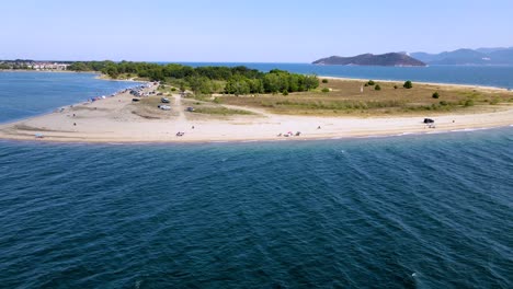 Tracking-aerial-clip-over-a-tropical-beach-with-golden-sand-in-the-area-of-Keramoti,-Kavala,-in-Northern-Greece-in-4k