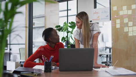 animation of data processing and diagrams over diverse female colleagues discussing work in office