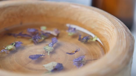 wooden bowl with dried flowers and essential oil