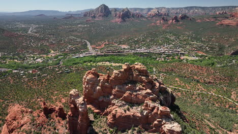 Aerial-descending-view-over-unique-red-hued-sandstone-spires-of-Sedona-mountains