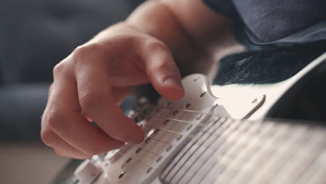 le mani di un uomo irriconoscibile che suona una chitarra elettrica