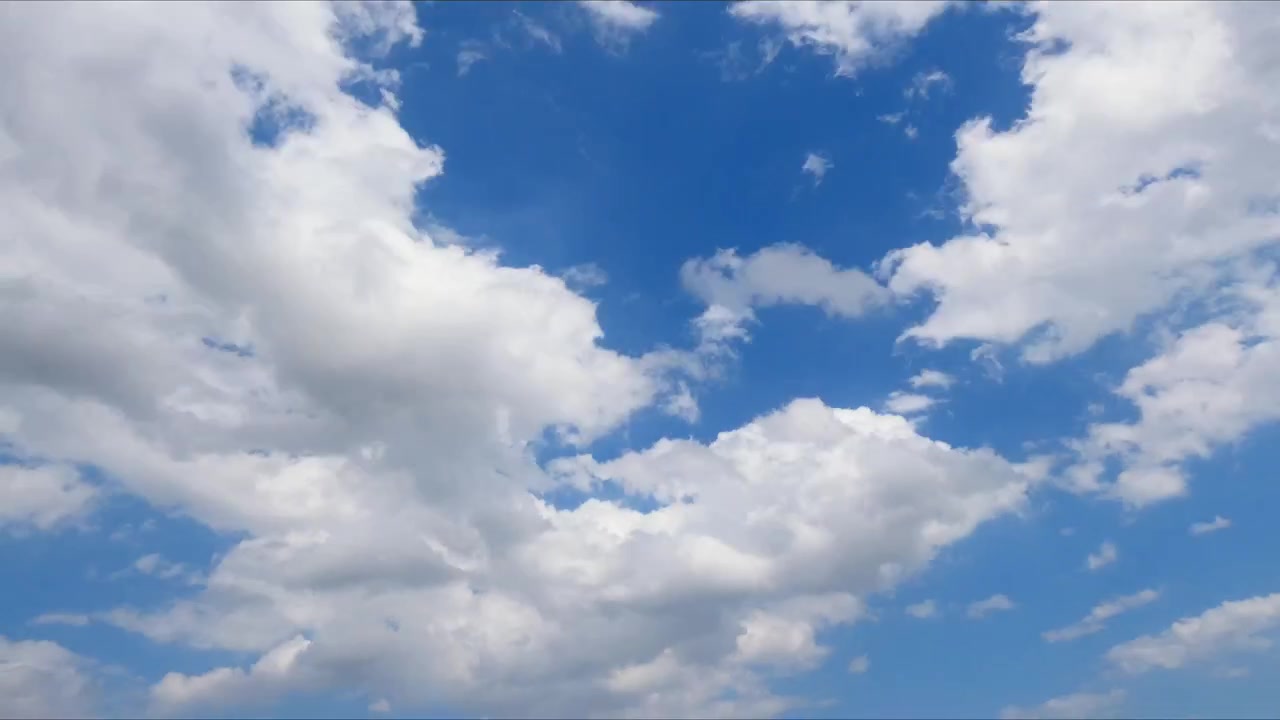 Timelapse of clouds drifting across a bright blue sky, showcasing natural atmospheric movement and changing weather in a peaceful outdoor scene.