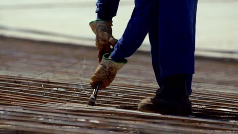 a rebar grid is tied together with wire before pouring the cement foundation