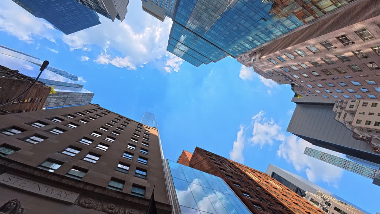 New York, USA, 1 August 2025: Busy street in Midtown Manhattan with skyscrapers. Street view of Manhattan with cars, traffic, and tall buildings under bright sky