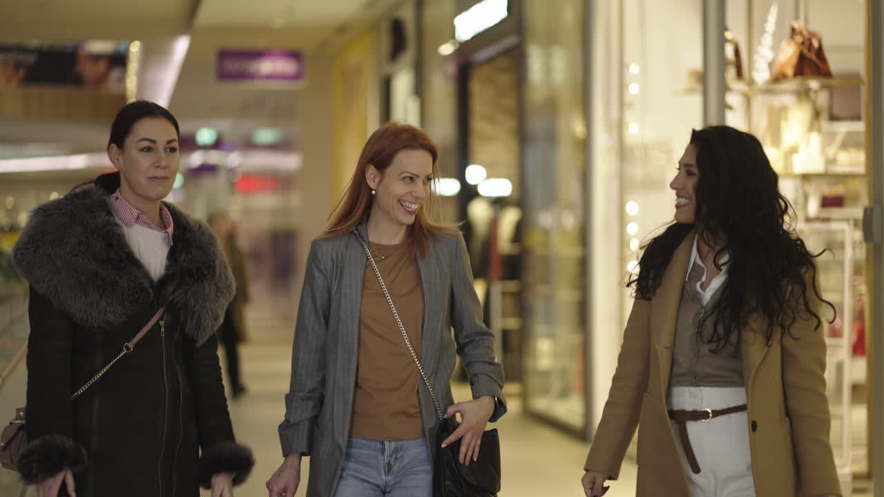 Three women friends walking and talking in a shopping mall